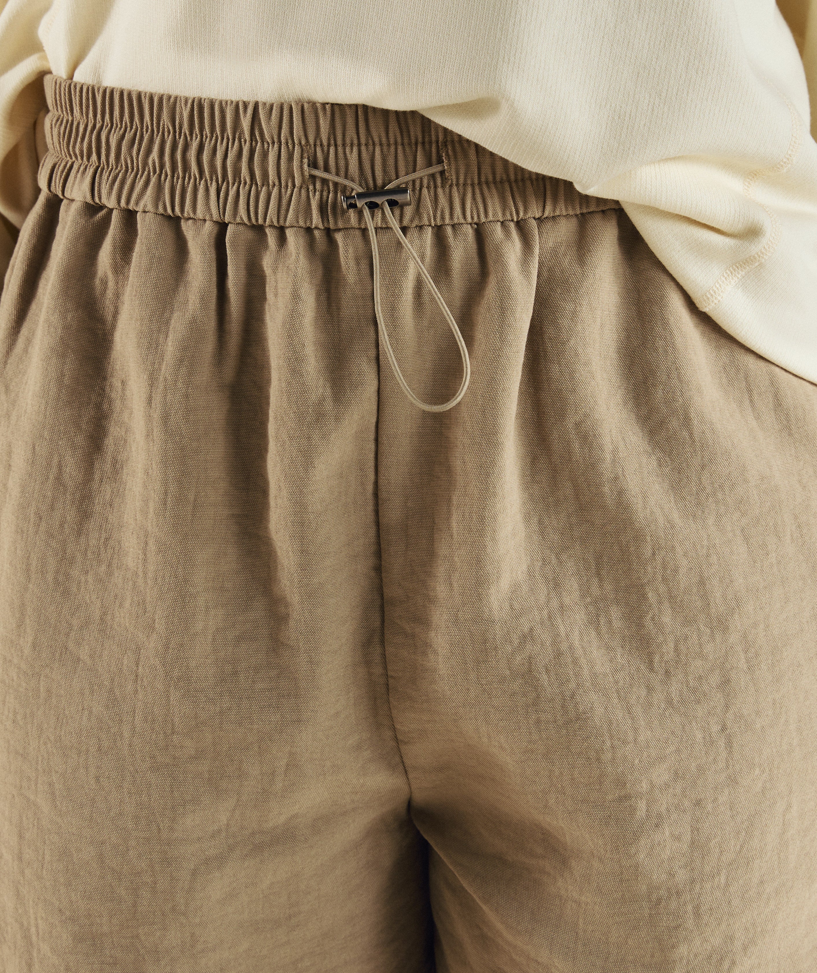 Woman wearing FOM ladies elasticated shorts in tahini
