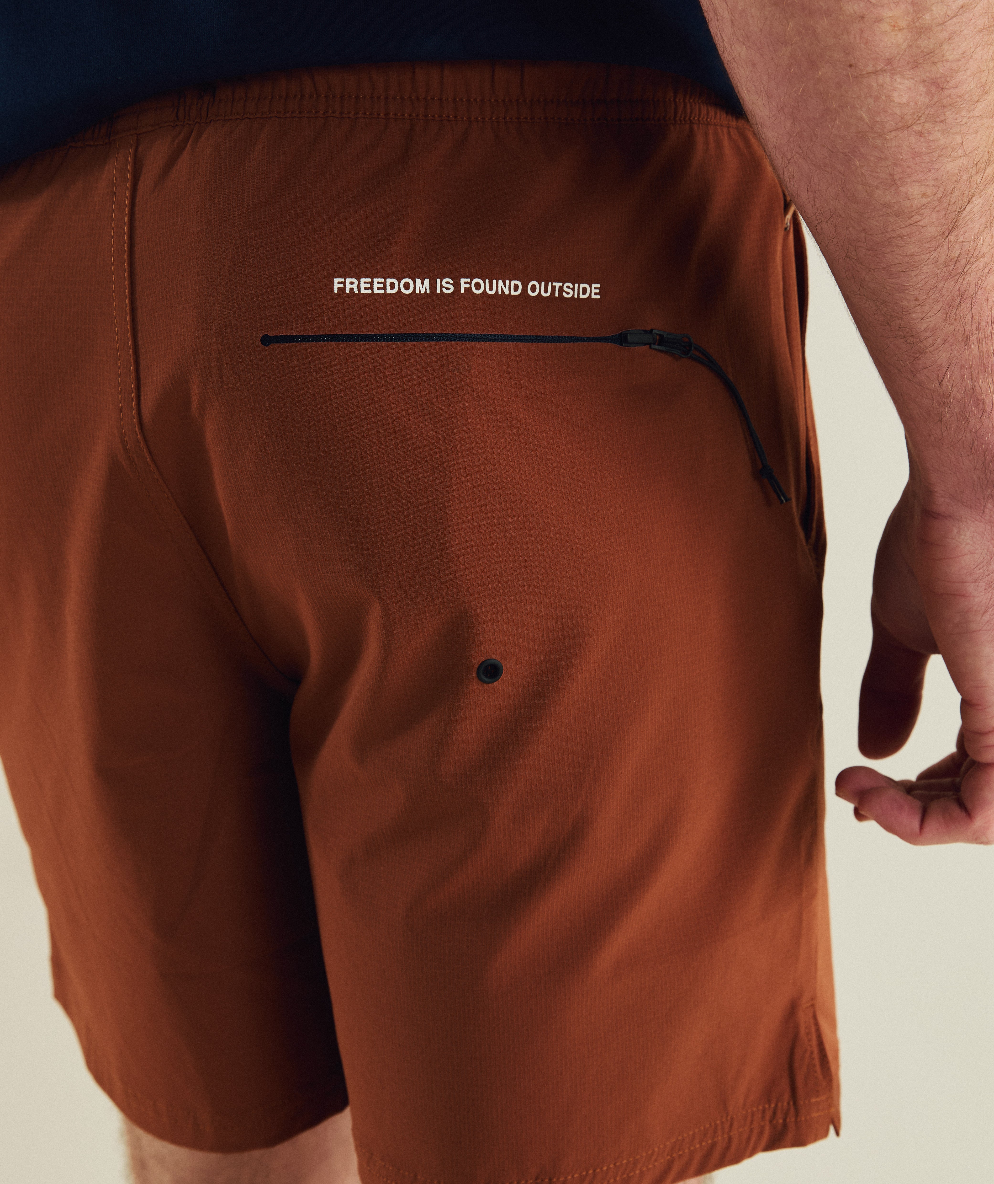 Man wearing FOM freemotion micro ripstop shorts in rust